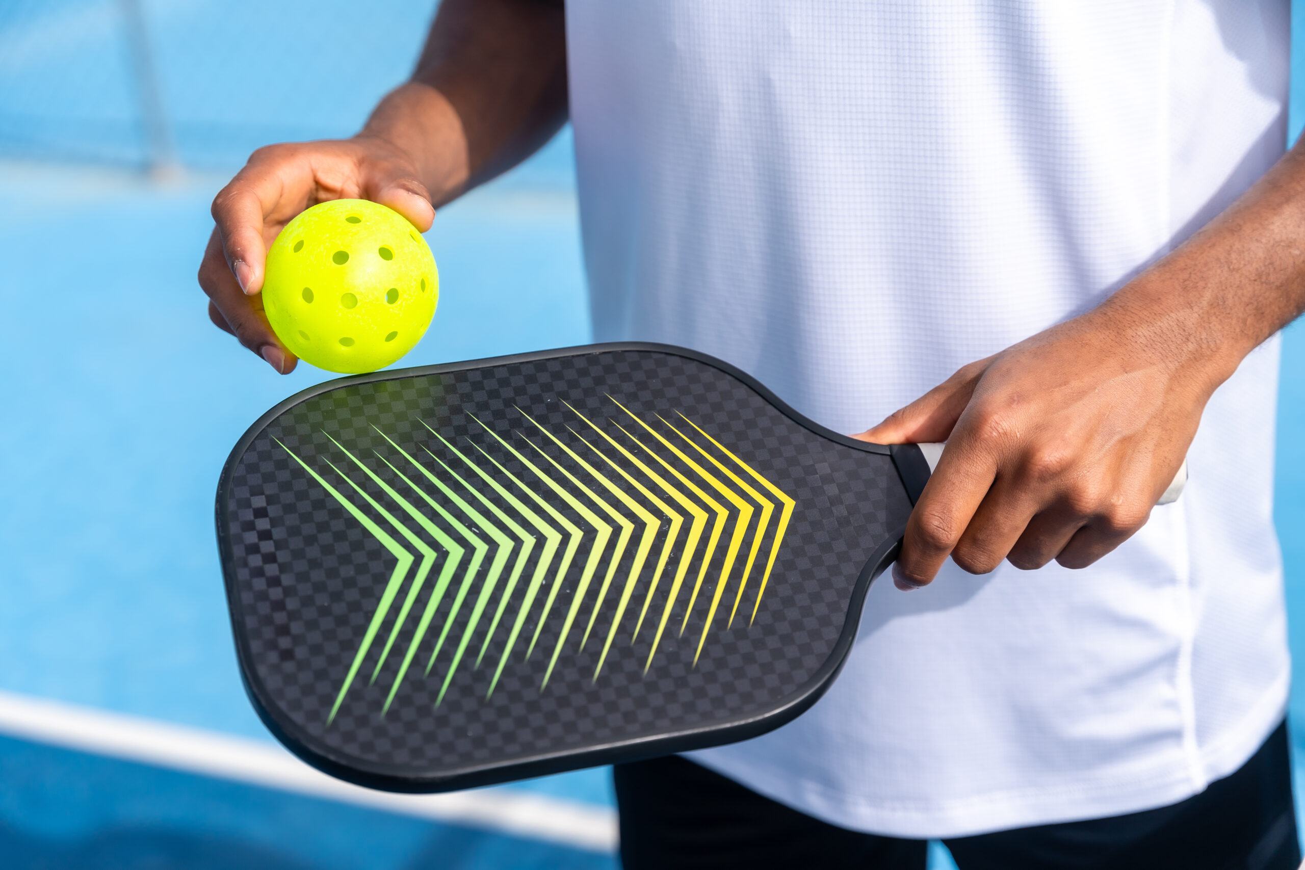 Unrecognizable close up sportive man with pickleball equipment